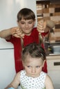 Brother and sister in the kitchen and the boy pulls the girl by the tails