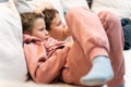 Brother and sister lying comfotable sofa and waching TV exciting movie Royalty Free Stock Photo