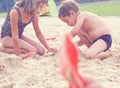 Little cute boy with plastic spatula in hand makes sand castle at the beach. Royalty Free Stock Photo