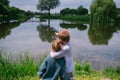 Brother and sister is near a pond. Two children standing in the tall grass near a pond Royalty Free Stock Photo