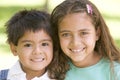 Brother and sister outdoors smiling