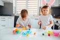 Brother and sister painting Easter eggs. Children make holiday decorations while sitting at the kitchen table. Royalty Free Stock Photo