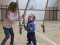 Brother and sister play with climbing ropes and laughing