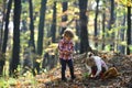 Brother and sister play on fresh air. Kids harvest grass in autumn forest. Small boy and girl friends have fun in woods