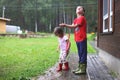 Brother and sister play in rainy weather Children jump in puddle and mud in the rain.