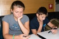 Brother and sister play with a smartphone waiting to have lunch Royalty Free Stock Photo