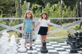 Brother and sister playing on big chess board. Little boy and girl kids enjoying spring. Kids walking at backyard. Best Royalty Free Stock Photo
