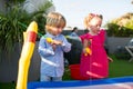 Brother and sister playing fishing in the kiddie pool. Royalty Free Stock Photo