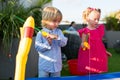 Brother and sister playing fishing in the kiddie pool. Royalty Free Stock Photo