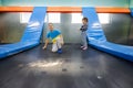 Brother with sister playing at indoor play center playground , jumping in trampoline Royalty Free Stock Photo