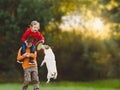 Brother and sister playing together with family pet dog and flying disc on Fall day Royalty Free Stock Photo