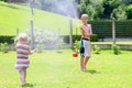 Brother and sister playing with water hose in the garden Royalty Free Stock Photo