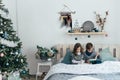 Brother and sister read an interesting book sitting in bed Royalty Free Stock Photo