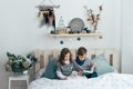 Brother and sister read an interesting book sitting in bed Royalty Free Stock Photo