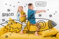 brother and sister riding drawn rocket in space while sitting on sofa