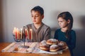 Brother and sister siblings lighting candles on menorah for Jewish Hanukkah holiday at home. Children celebrating Chanukah Royalty Free Stock Photo