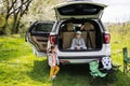 Brother with sister sit on car open trunk at picnic Royalty Free Stock Photo