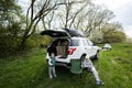 Brother with sister sit on chair against car on picnic Royalty Free Stock Photo