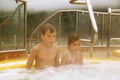 Brother and sister sit in pool with hot water