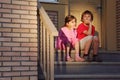 Brother and sister sit on stairs