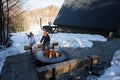 Brother with sister sitting by camp bonfire on winter against tiny house. Children in countryside Royalty Free Stock Photo