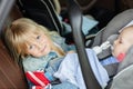 Brother and sister sitting in car in safety seat. Siblings on passenger places having fun together during travel by Royalty Free Stock Photo