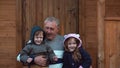 Brother and sister sitting on the grandfather s knees. Old man hugs his grandson and granddaughter. 4K