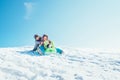 Brother and sister slide down from the snow slope sitting in one Royalty Free Stock Photo