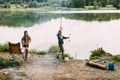 A brother and sister are standing on the river bank and fishing during a family vacation at a camping site. Time Royalty Free Stock Photo