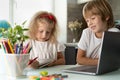 brother and sister study at home at laptop, children and gadgets