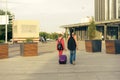 Brother and sister with a suitcase, backpack and guitar go to the station