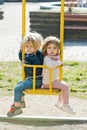 Brother and sister on swing on sunny day Royalty Free Stock Photo