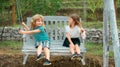 Brother and sister swinging outside. Little boy and girl working in the garden. Two happy children in summer park. Kids Royalty Free Stock Photo