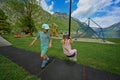 Brother with sister swinging in playground at Hallstatt, Austria Royalty Free Stock Photo