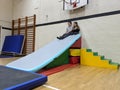 A brother and sister it on top of their base made from soft play equipment