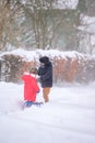 Brother and sister walk in a snowy yard, having fun with snow. Royalty Free Stock Photo