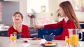 Brother And Sister Wearing School Uniform In Kitchen Have Fun Hanging Spoon From Nose At Breakfast Royalty Free Stock Photo