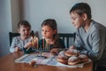 Brother and sisters siblings lighting candles on menorah for Jewish Hanukkah holiday at home. Children celebrating Chanukah Royalty Free Stock Photo