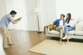 Brother takes a picture of his father and sister enjoying in their living room at home. Royalty Free Stock Photo