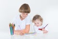 Brother and toddler sister paiting in white room Royalty Free Stock Photo