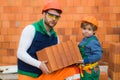 Brothers bricklayers make masonry, builders work with brick layer. Royalty Free Stock Photo