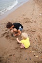 Two brothers children playing on the sand beach by the sea Royalty Free Stock Photo