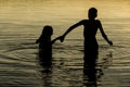 Brothers Holding hands in the water of a lake at sunset Royalty Free Stock Photo