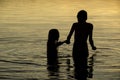 Brothers Holding hands in the water of a lake at sunset Royalty Free Stock Photo