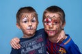 The brothers hug and look at the camera. Childrens with face painting