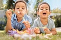 Brothers kids blowing bubbles in park, garden and backyard, grass and nature fun, joy and happy youth development Royalty Free Stock Photo