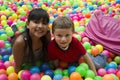 Brothers lays on the big heap of multicolored small balls.