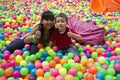 Brothers lays on the big heap of multicolored small balls.