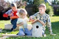 Brothers making wooden birdhouse by hands. Kid teenager teaches his younger brother.