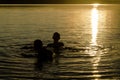 Brothers playing in the water of a lake at sunset Royalty Free Stock Photo